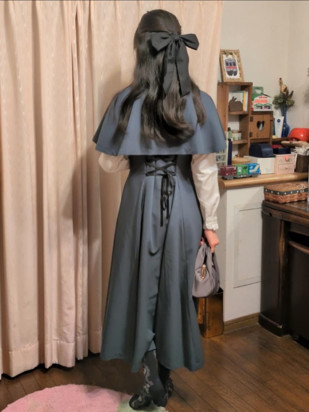 グリーン系のワンピース、グレー系のハンドバッグ、ホワイト系のシャツ/ブラウスを着用したレディースの春コーディネートの2枚目の写真