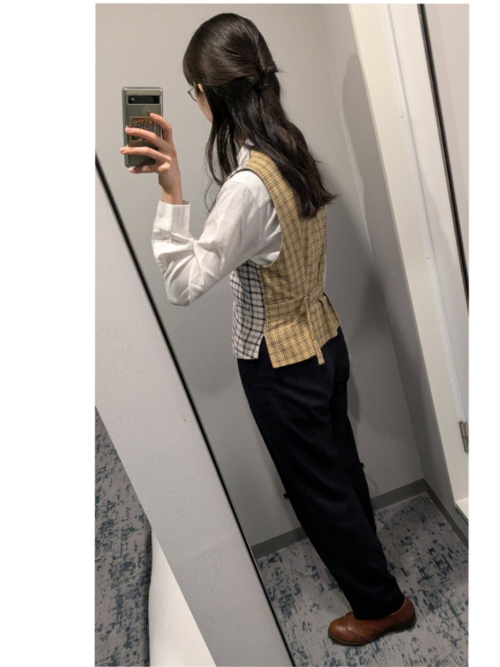 ブルー系のスラックス、ブラウン系のドレスシューズ、ブルー系のベストを着用したレディースの春コーディネートの2枚目の写真