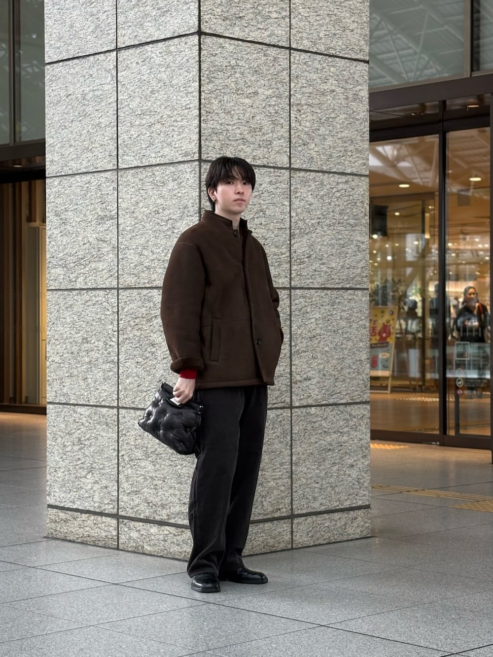 ブラウン系のその他アウター、グレー系のその他パンツ、ブラウン系のニット/セーターを着用したメンズの秋コーディネートの2枚目の写真