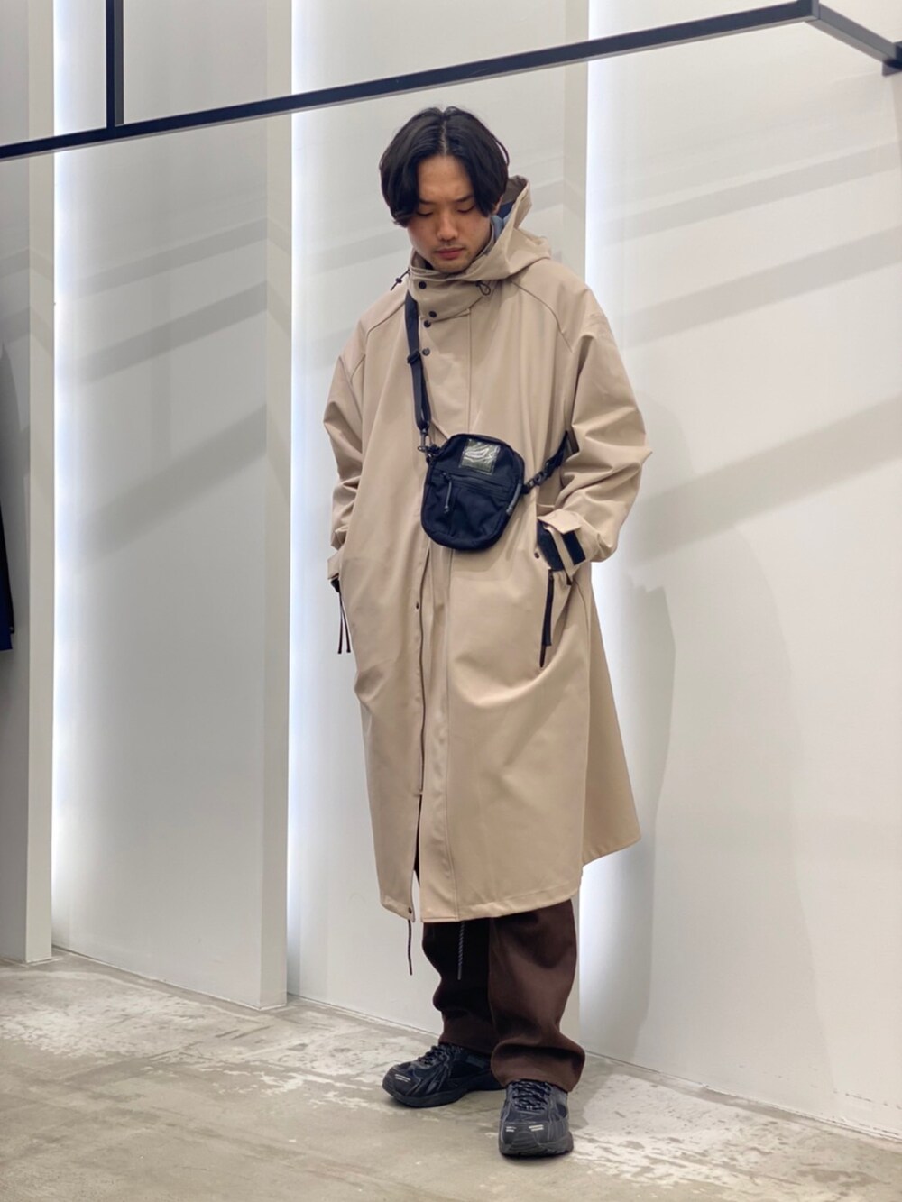 「モッズコート、ショルダーバッグ、ロング丈、ホワイトコーデ、きれいめカジュアル、フレアパンツ、メガネ男子」｜「URBAN RESEARCHのGOODBETTERBEST　モッズコート（モッズコート、ベージュ系）」を使った、新村優樹さん（メンズ・177cm）の冬コーディネートの2枚目の写真