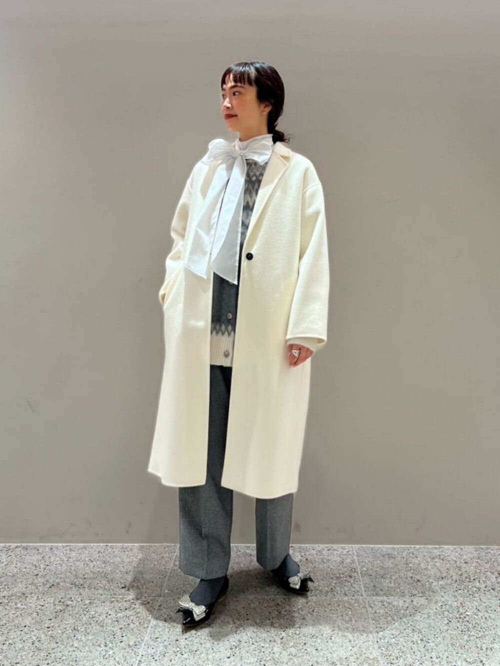 シルバー系のスラックス、グレー系のカーディガン/ボレロ、その他のシャツ/ブラウスを着用したレディースの冬コーディネートの2枚目の写真