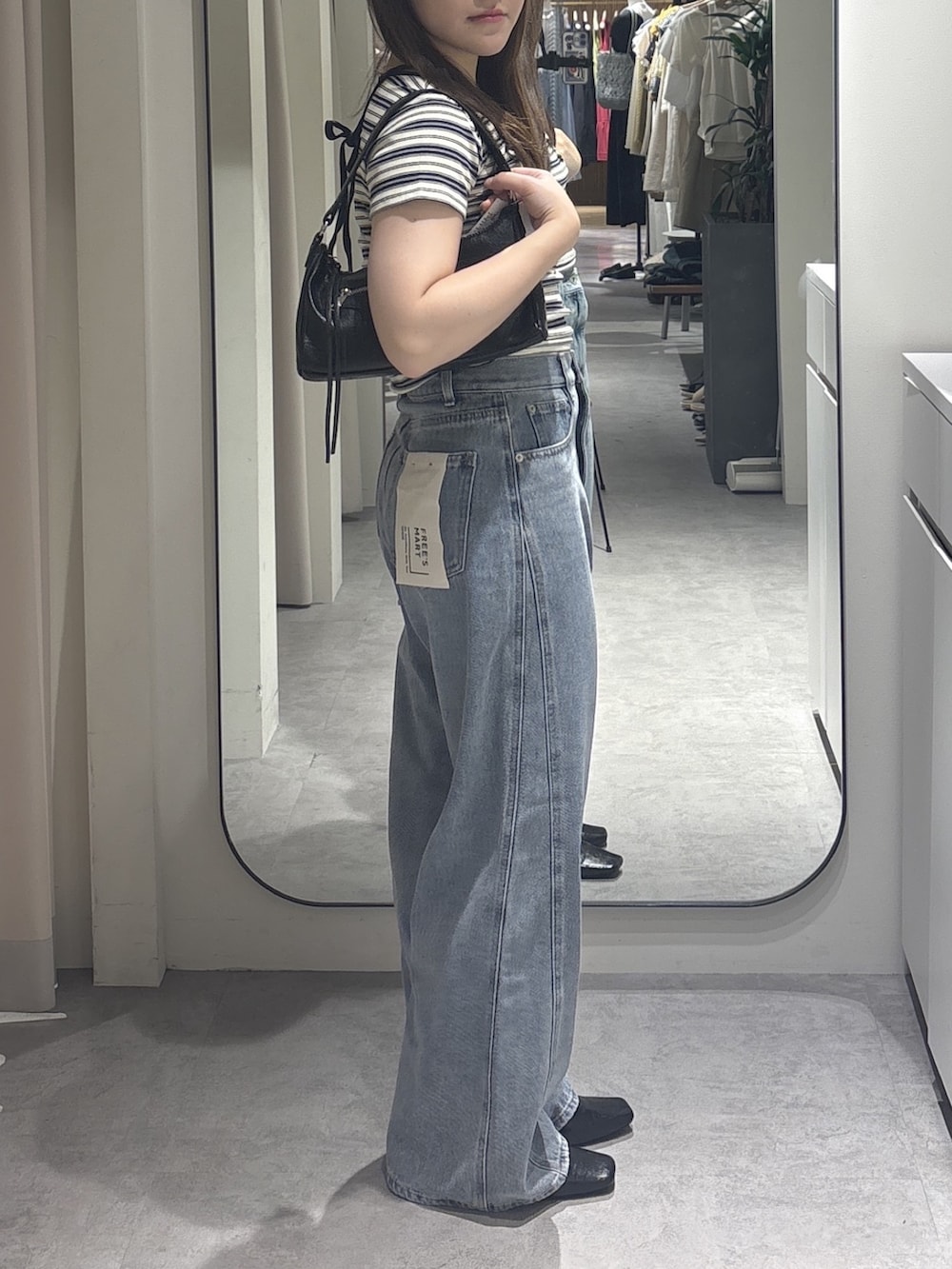 ホワイト系のTシャツ/カットソー、ブルー系のデニムパンツ、ブラック系のショルダーバッグを着用したレディースの夏コーディネートの2枚目の写真