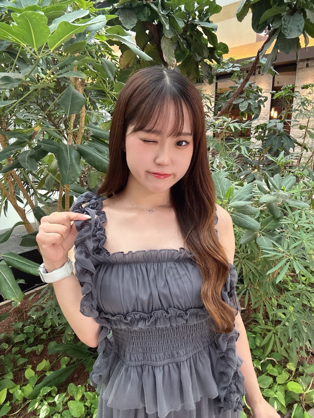 グレー系のスカート、グレー系のシャツ/ブラウス、ホワイト系のサンダルを着用したレディースの夏コーディネートの3枚目の写真