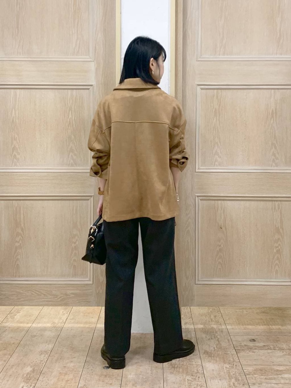 ブラック系のショルダーバッグ、ブラック系のブーツ、ブラウン系のテーラードジャケットを着用したレディースの春コーディネートの3枚目の写真