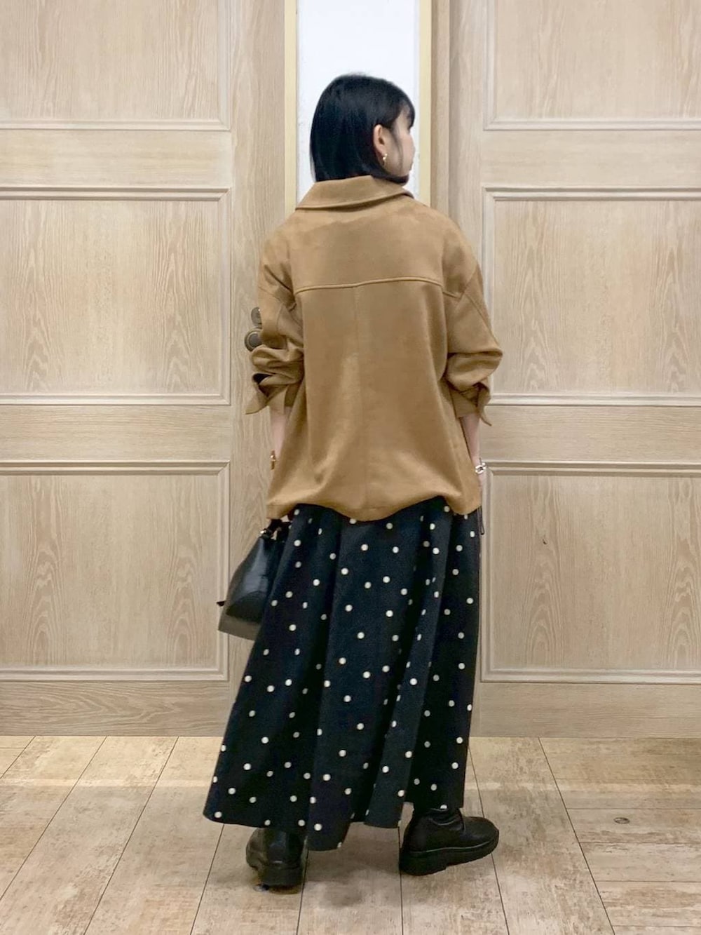 ブラック系のショルダーバッグ、ブラック系のブーツ、ブラウン系のテーラードジャケットを着用したレディースの冬コーディネートの3枚目の写真