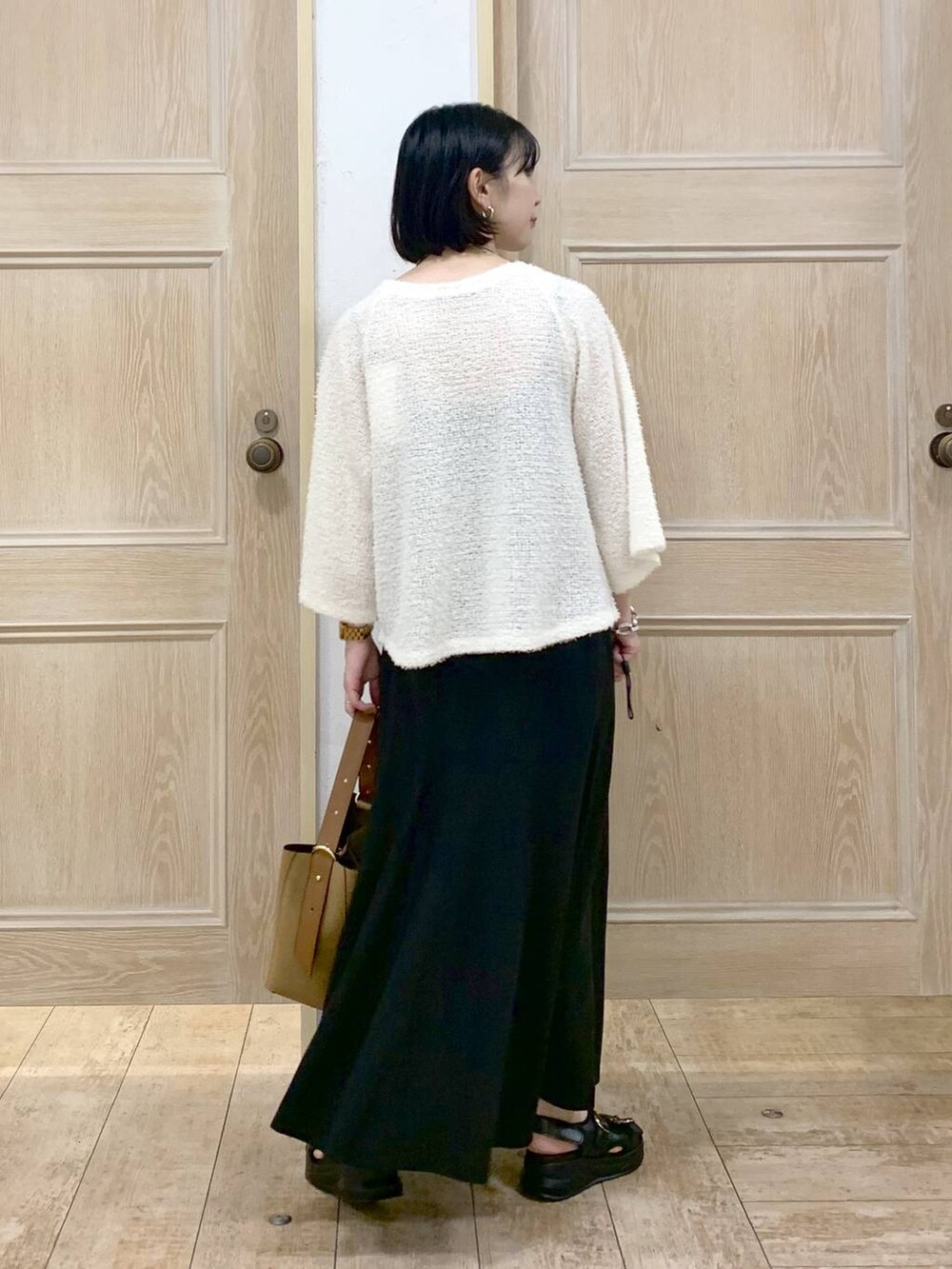 ブラウン系のショルダーバッグ、ブラック系のサンダル、ベージュ系のTシャツ/カットソーを着用したレディースの秋コーディネートの3枚目の写真