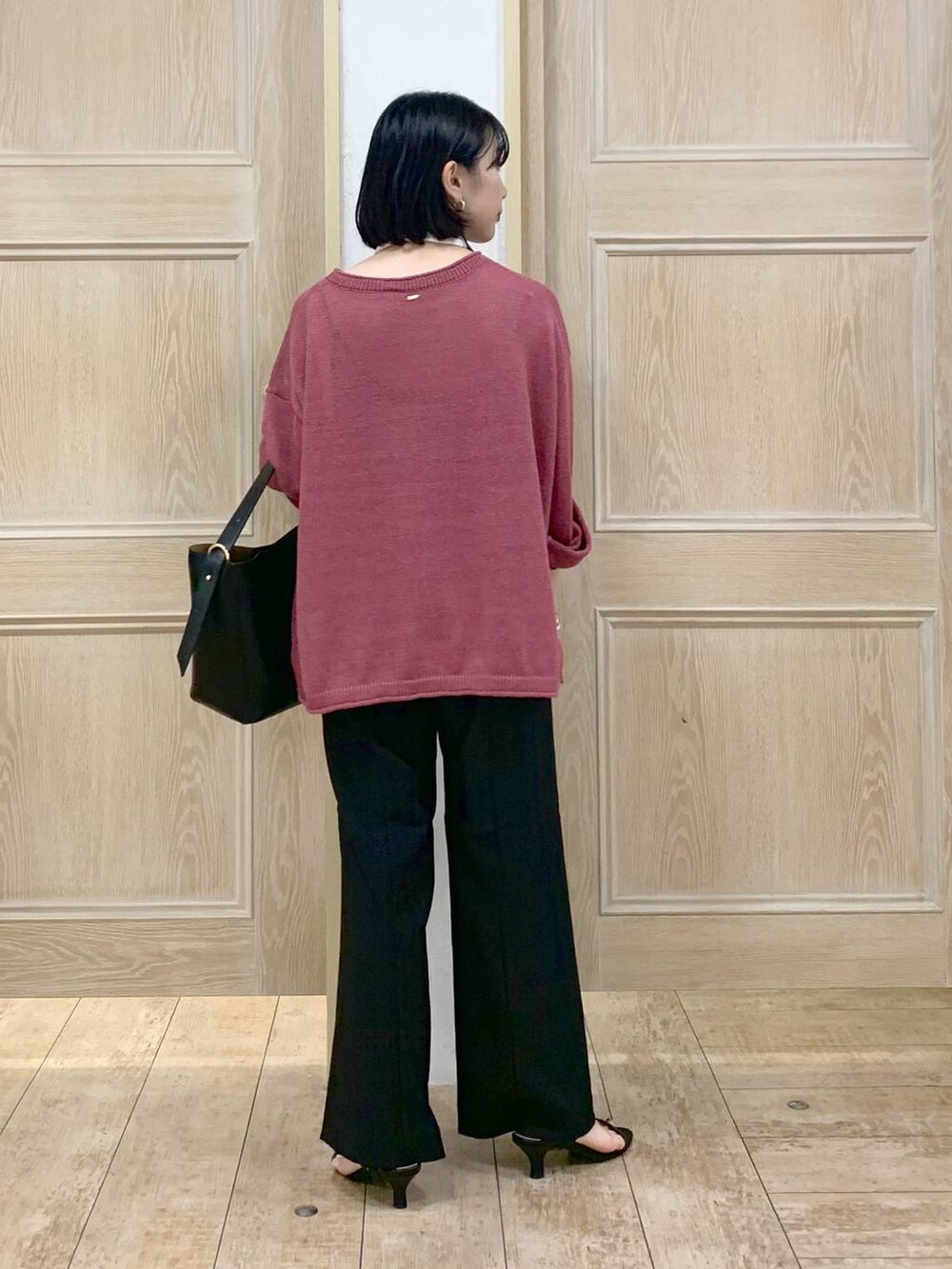 ブラック系のショルダーバッグ、ブラック系のサンダル、レッド系のニット/セーターを着用したレディースの秋コーディネートの3枚目の写真