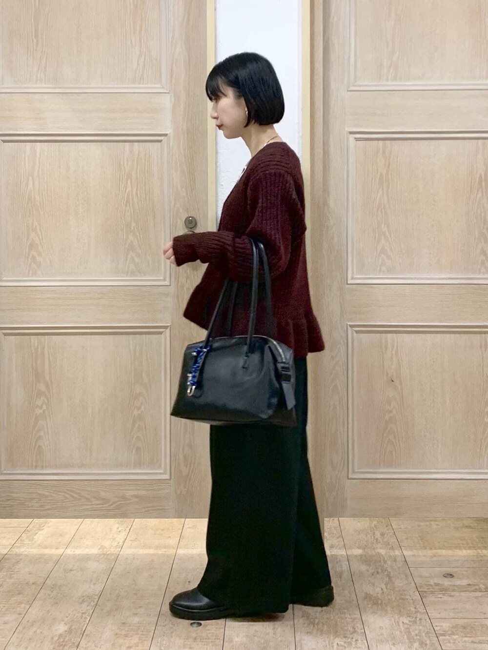 ブラック系のボストンバッグ、ホワイト系のTシャツ/カットソー、ブラック系のその他パンツを着用したレディースの冬コーディネートの2枚目の写真