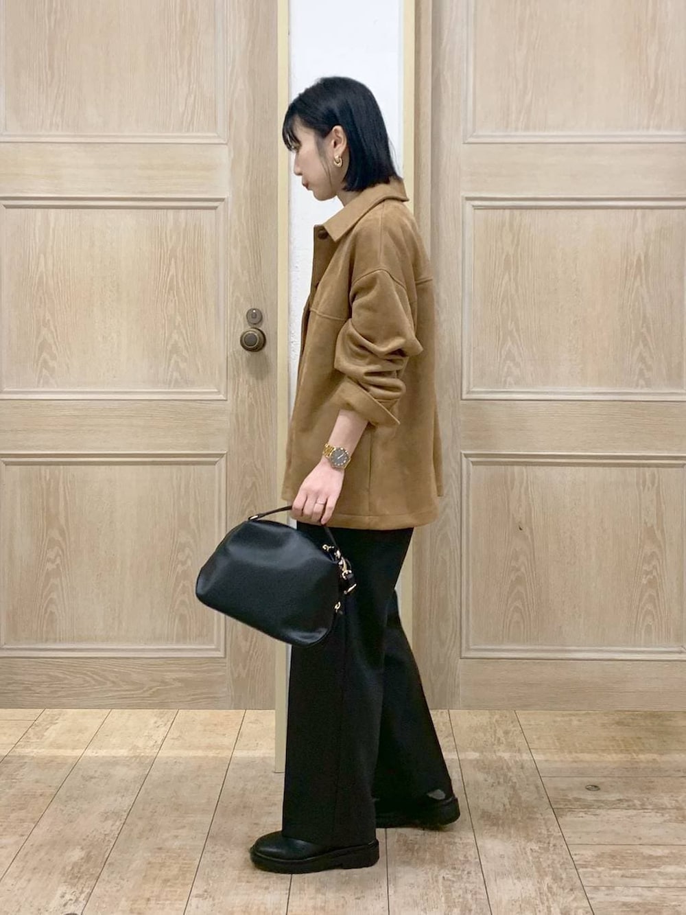 ブラック系のショルダーバッグ、ブラック系のブーツ、ブラウン系のテーラードジャケットを着用したレディースの春コーディネートの2枚目の写真