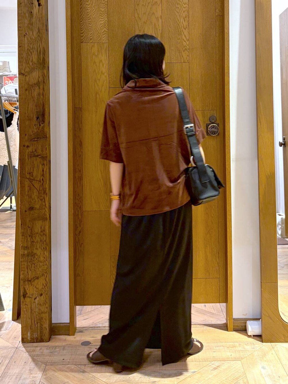 ブラック系のスカート、ブラック系のサンダル、ブラック系のショルダーバッグを着用したレディースの夏コーディネートの3枚目の写真
