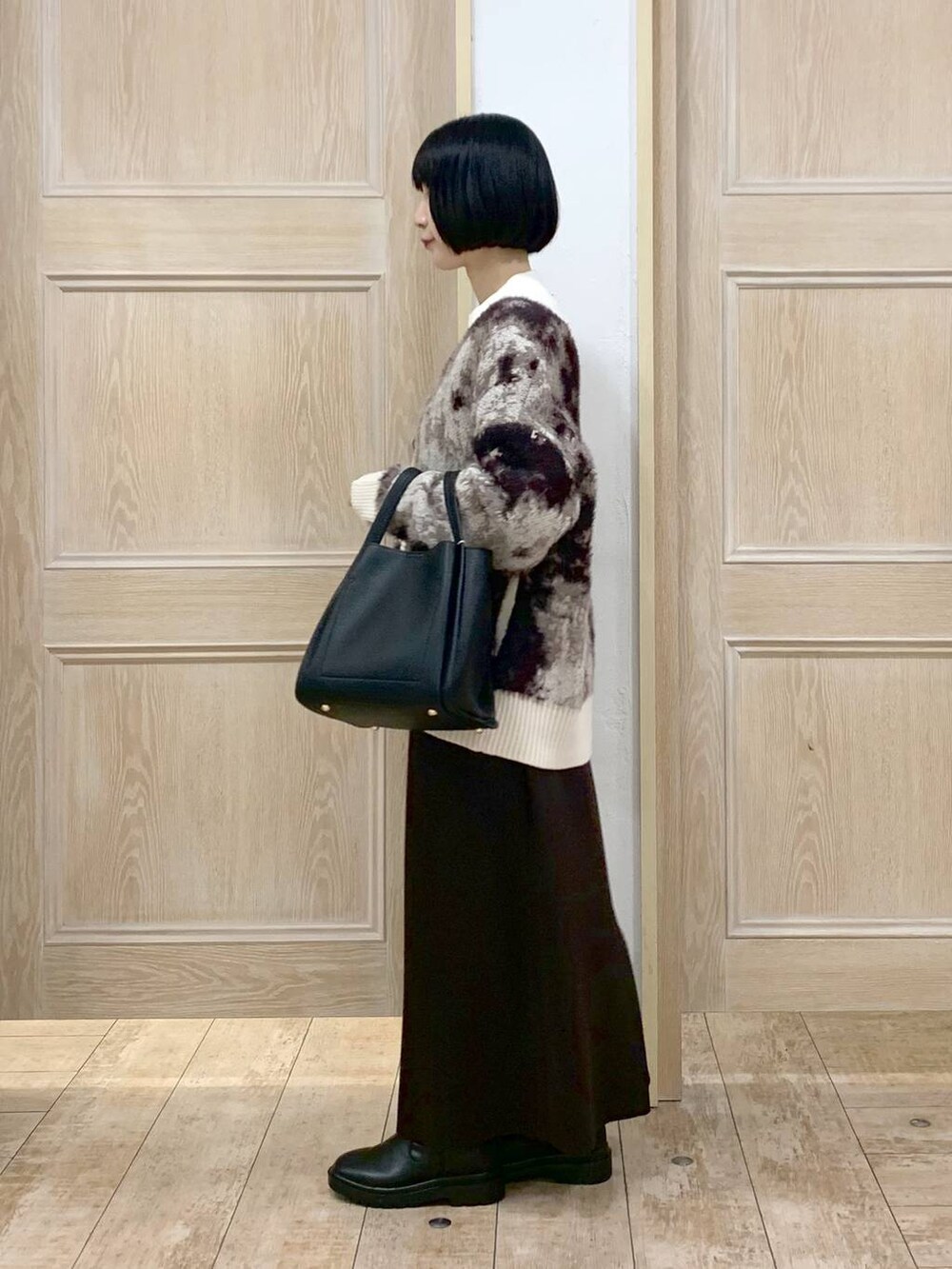 ホワイト系のニット/セーター、ブラック系のトートバッグ、イエロー系のワンピースを着用したレディースの秋コーディネートの2枚目の写真