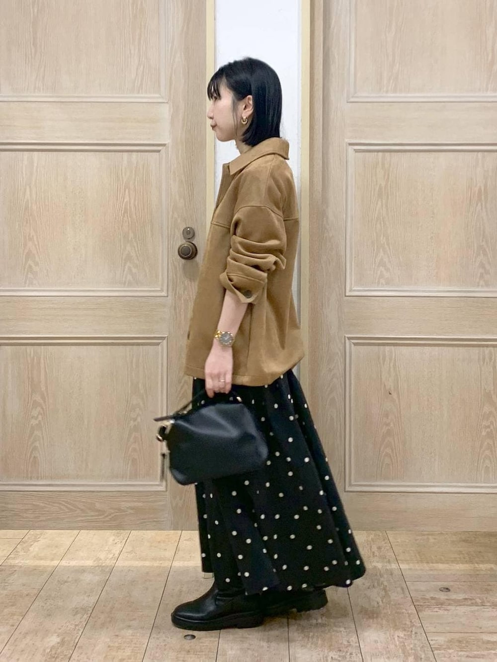 ブラック系のショルダーバッグ、ブラック系のブーツ、ブラウン系のテーラードジャケットを着用したレディースの冬コーディネートの2枚目の写真