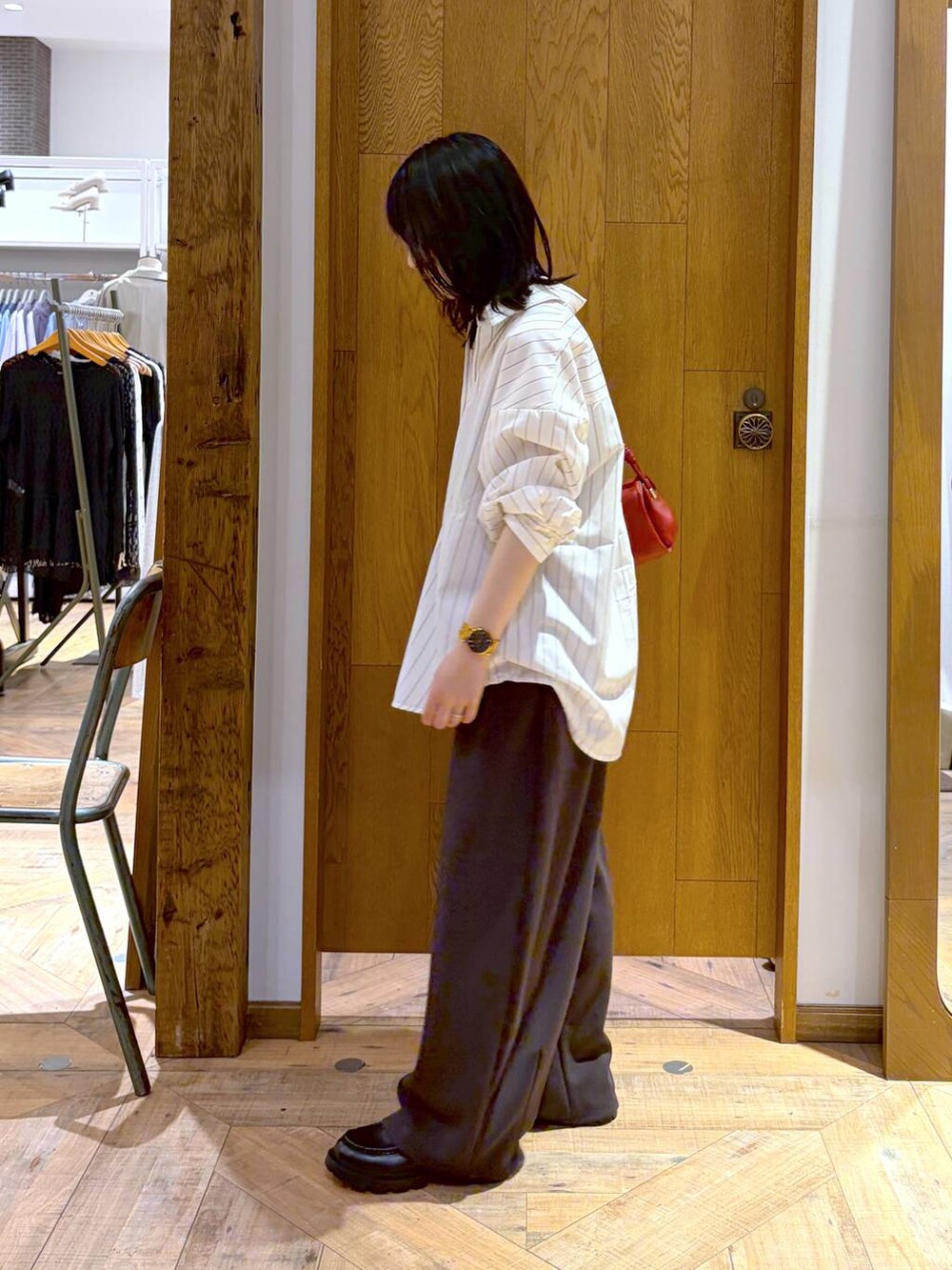 ブラック系のローファー、ホワイト系のシャツ/ブラウス、レッド系のショルダーバッグを着用したレディースの夏コーディネートの2枚目の写真