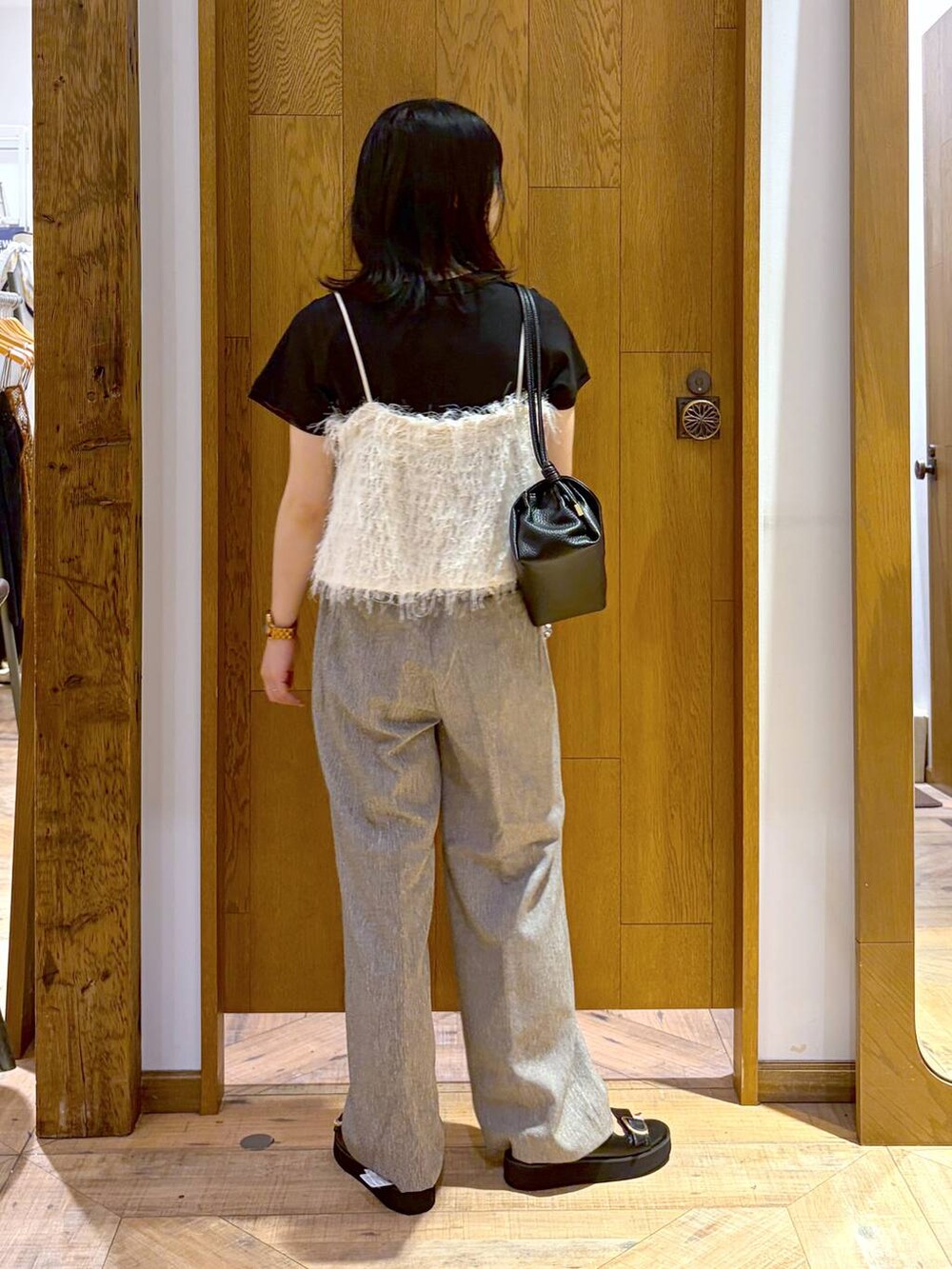 ブラック系のショルダーバッグ、ブラック系のサンダル、ブラック系のTシャツ/カットソーを着用したレディースの夏コーディネートの3枚目の写真