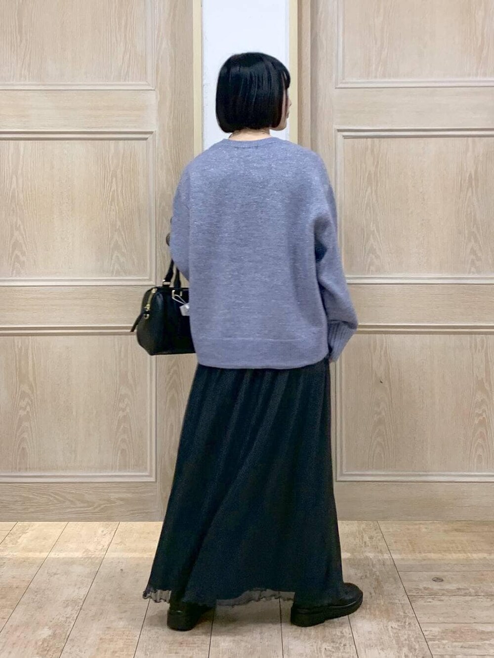 ブラック系のボストンバッグ、ブラック系のブーツを着用したレディースの冬コーディネートの3枚目の写真