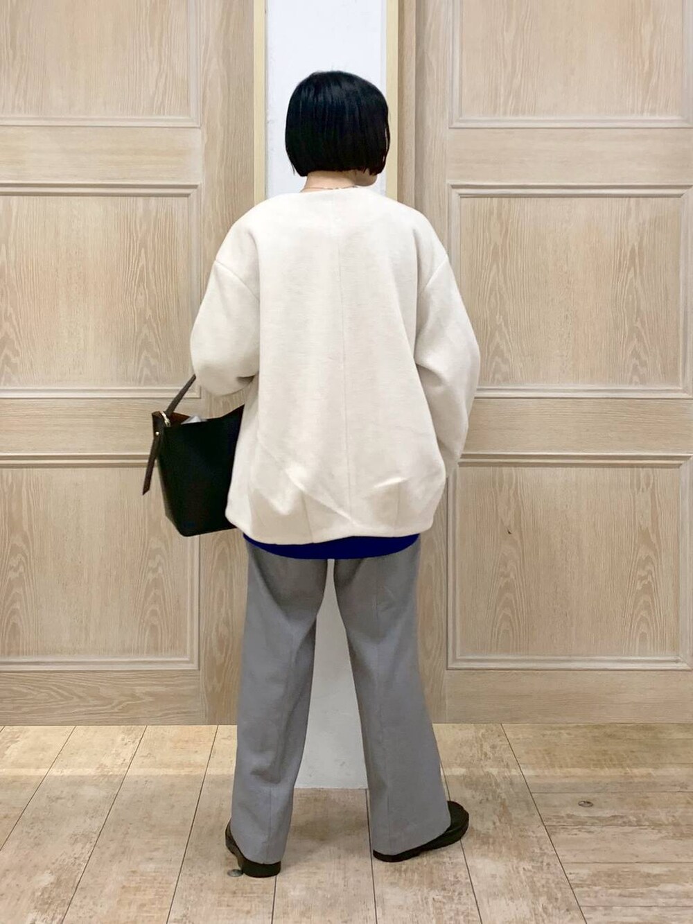 ブラック系のショルダーバッグ、ベージュ系のノーカラーコート、グレー系のその他パンツを着用したレディースの秋コーディネートの3枚目の写真