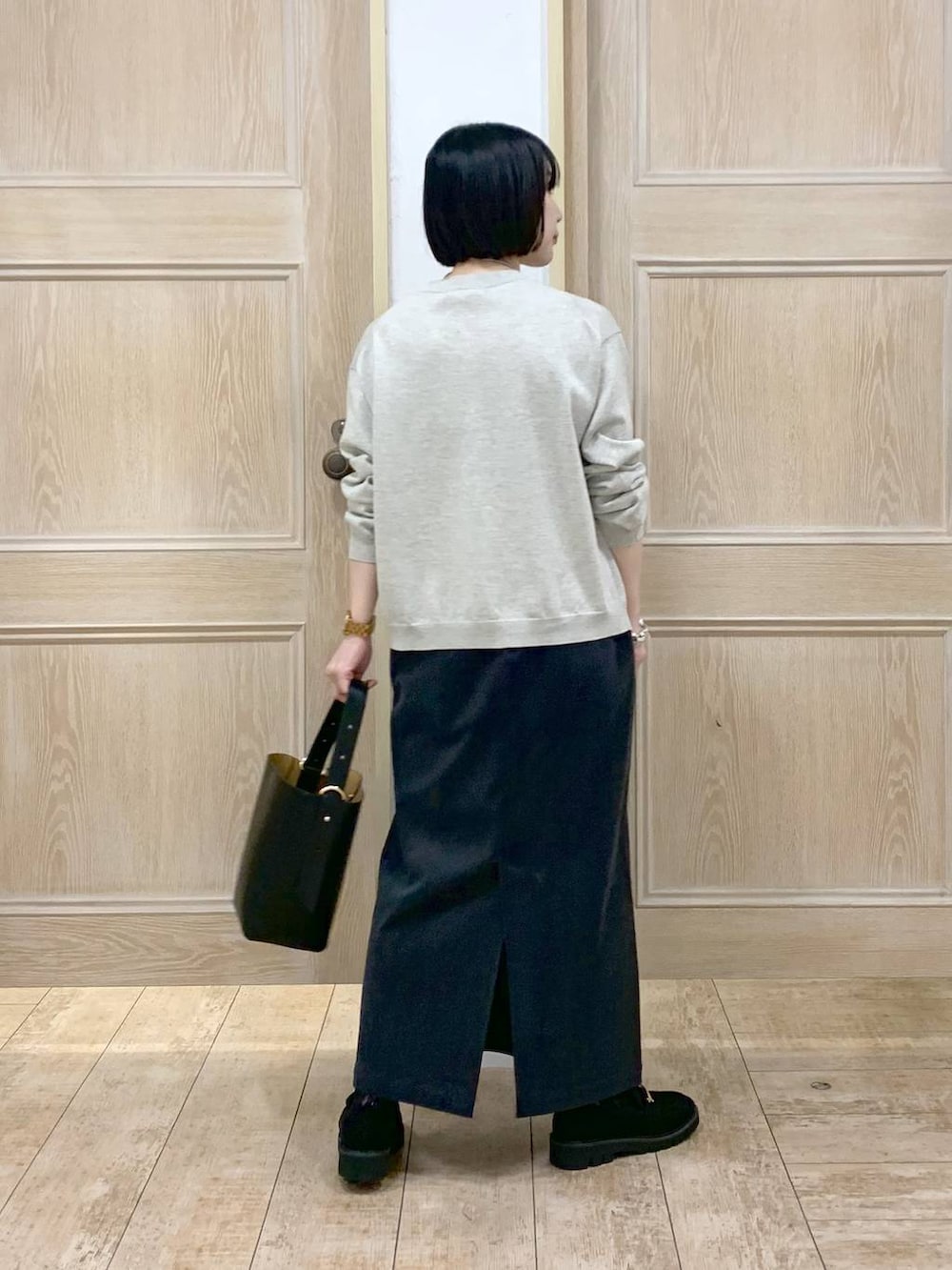 ブラック系のショルダーバッグ、グレー系のスカート、ブラック系のローファーを着用したレディースの秋コーディネートの3枚目の写真