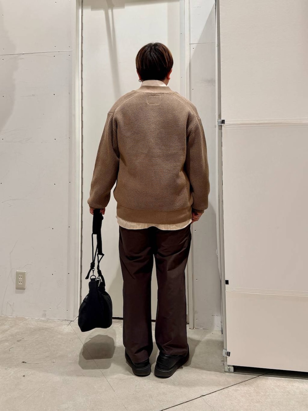 ブラック系のショルダーバッグ、ベージュ系のカーディガン/ボレロ、ベージュ系のシャツ/ブラウスを着用したメンズの冬コーディネートの4枚目の写真