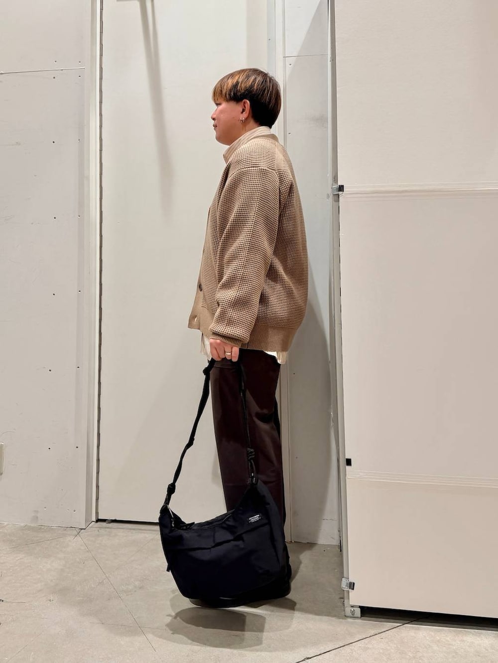 ブラック系のショルダーバッグ、ベージュ系のカーディガン/ボレロ、ベージュ系のシャツ/ブラウスを着用したメンズの冬コーディネートの3枚目の写真