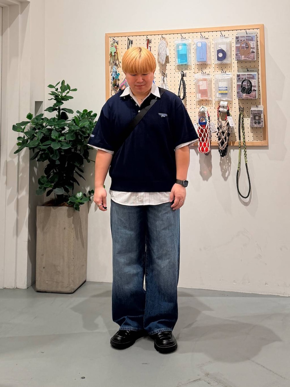 ブルー系のデニムパンツ、ブラック系のショルダーバッグ、ベージュ系のシャツ/ブラウスを着用したメンズの春コーディネートの2枚目の写真