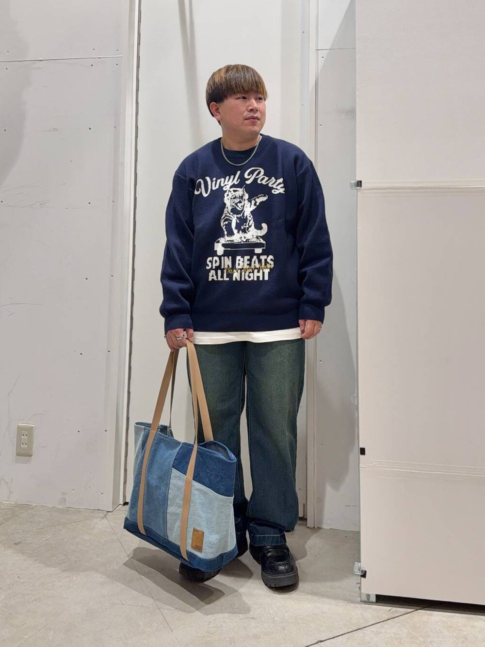 ホワイト系のTシャツ/カットソー、ブルー系のデニムパンツ、ブルー系のニット/セーターを着用したメンズの冬コーディネートの2枚目の写真