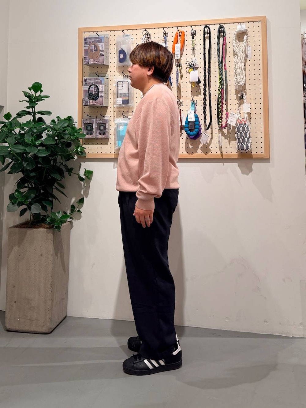 ブラック系のその他シューズ、ブルー系のスラックス、ピンク系のニット/セーターを着用したメンズの春コーディネートの3枚目の写真