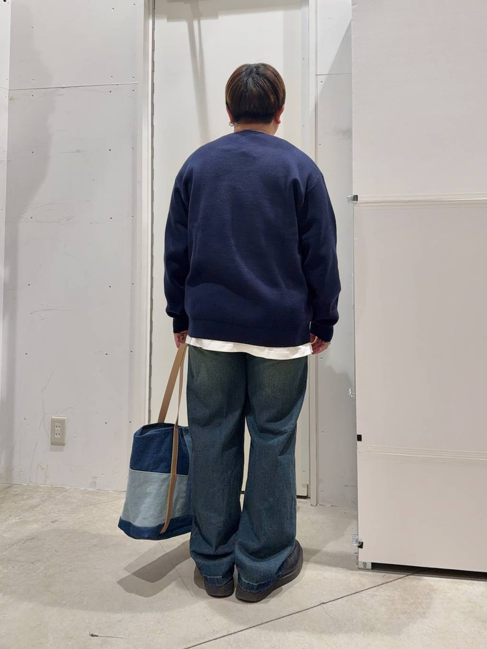 ホワイト系のTシャツ/カットソー、ブルー系のデニムパンツ、ブルー系のニット/セーターを着用したメンズの冬コーディネートの3枚目の写真