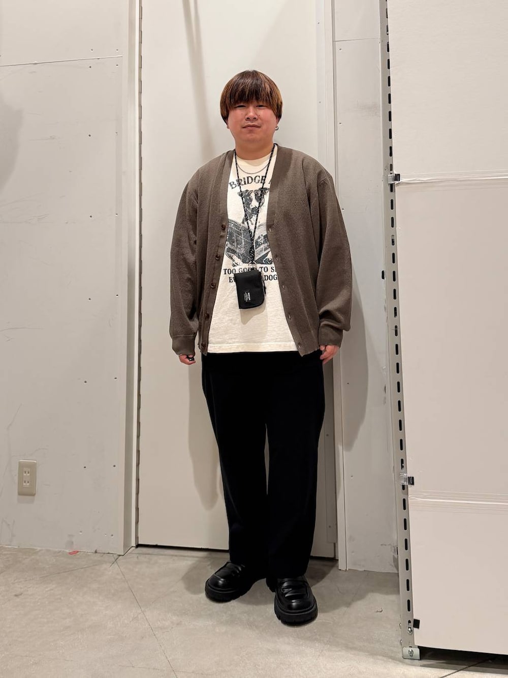 ブラック系のその他パンツ、グリーン系のカーディガン/ボレロ、ホワイト系のTシャツ/カットソーを着用したメンズの春コーディネートの4枚目の写真