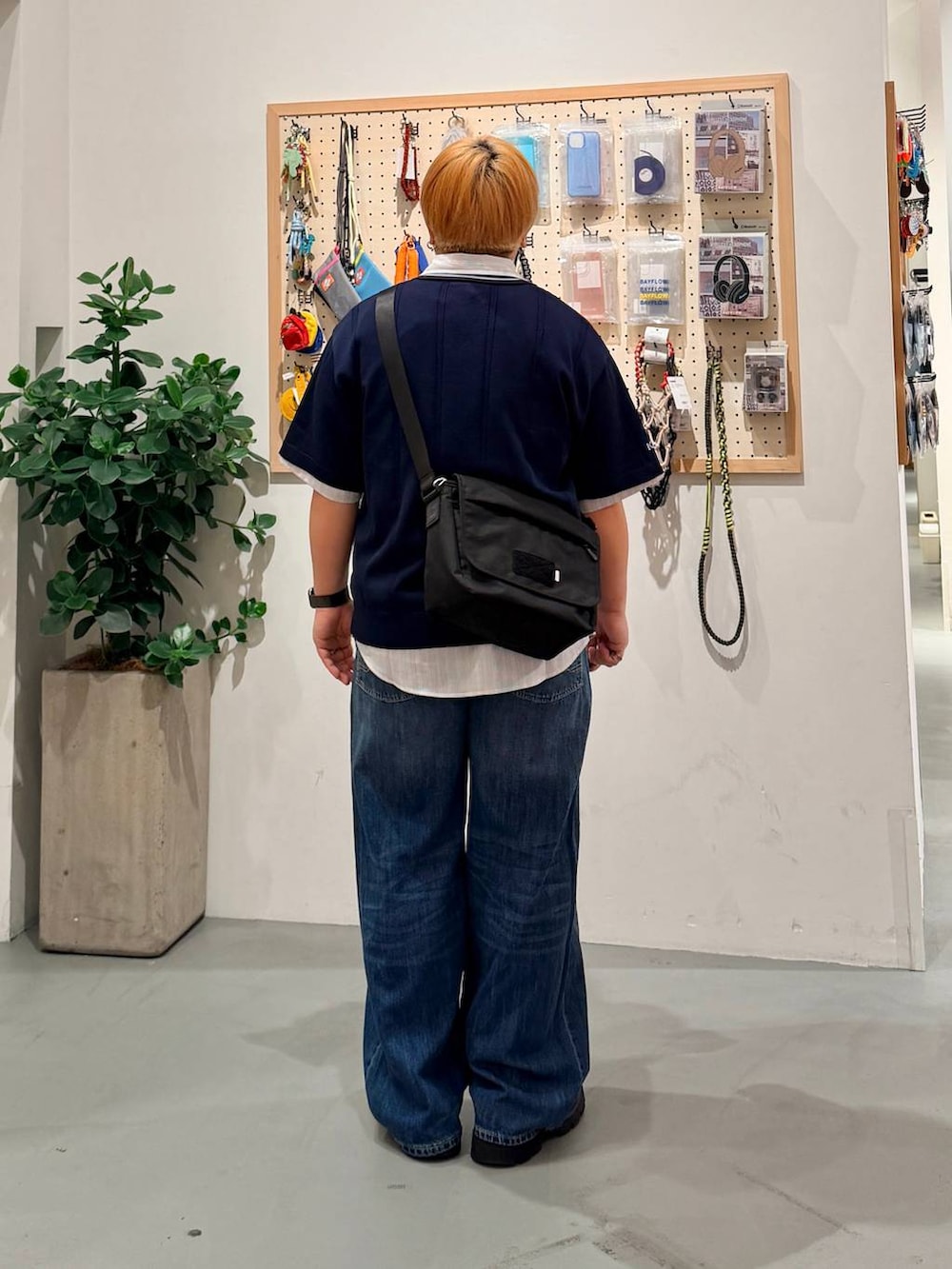 ブルー系のデニムパンツ、ブラック系のショルダーバッグ、ベージュ系のシャツ/ブラウスを着用したメンズの春コーディネートの4枚目の写真