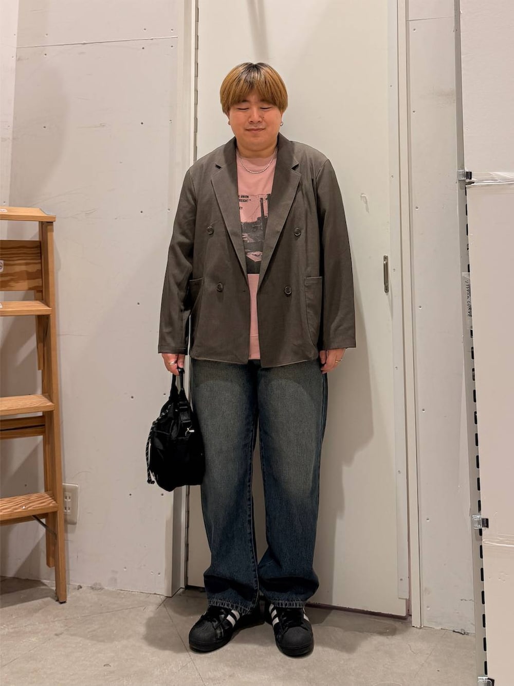 ブラウン系のテーラードジャケット、ピンク系のTシャツ/カットソー、ブルー系のデニムパンツを着用したメンズの秋コーディネートの2枚目の写真