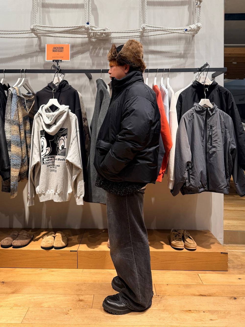 ブラック系のダウンジャケット/コート、ブラック系のデニムパンツ、ブラック系のニット/セーターを着用したメンズの冬コーディネートの3枚目の写真