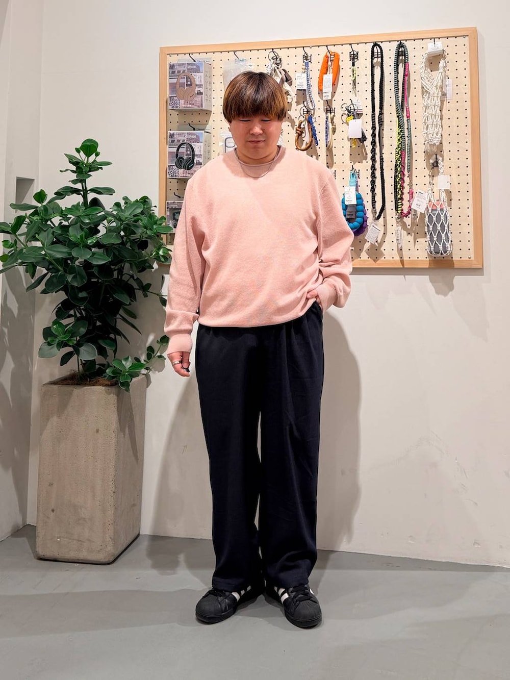 ブラック系のその他シューズ、ブルー系のスラックス、ピンク系のニット/セーターを着用したメンズの春コーディネートの2枚目の写真