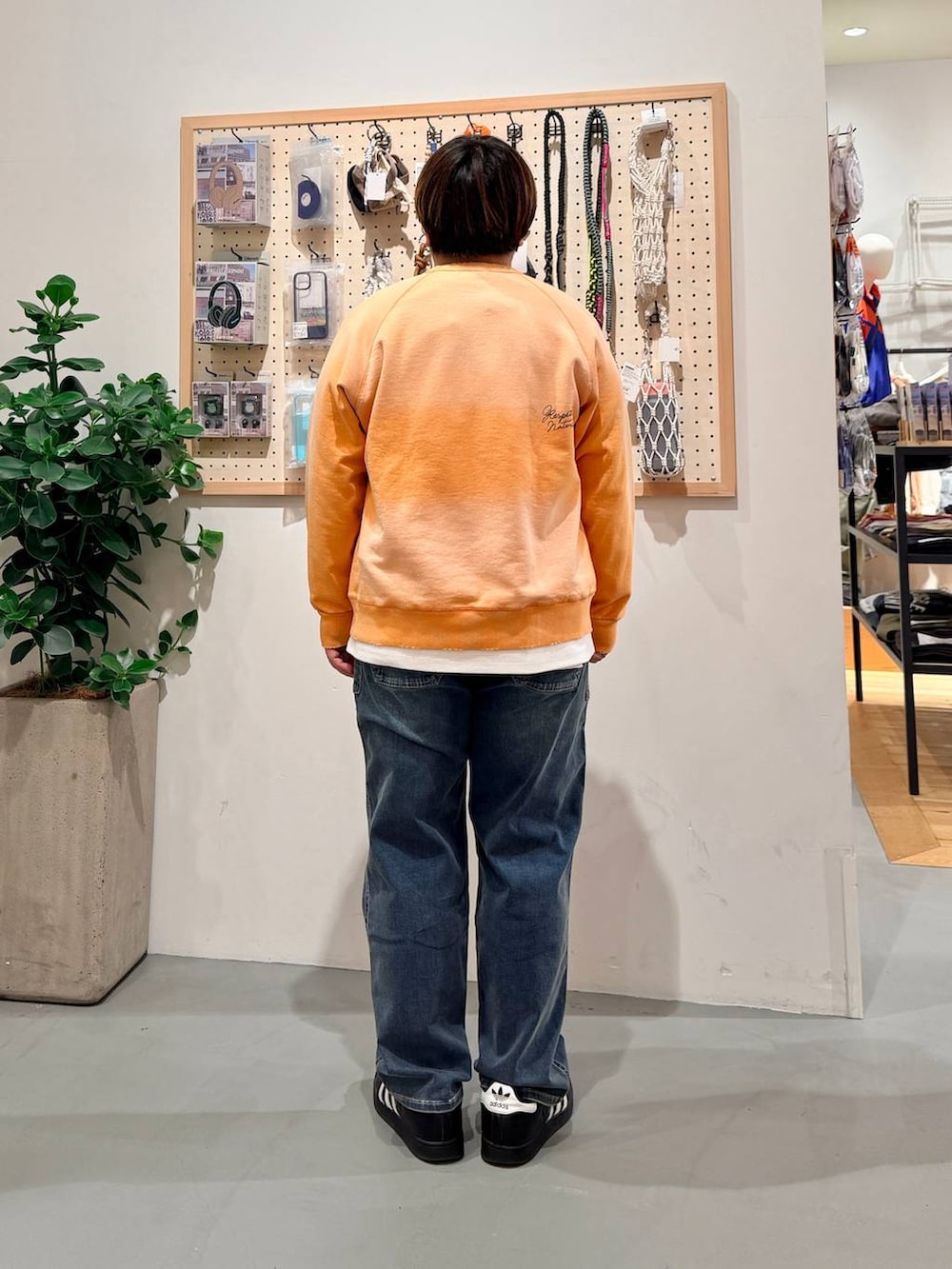 ブラック系のその他シューズ、ブルー系のデニムパンツ、オレンジ系のスウェットを着用したメンズの春コーディネートの4枚目の写真