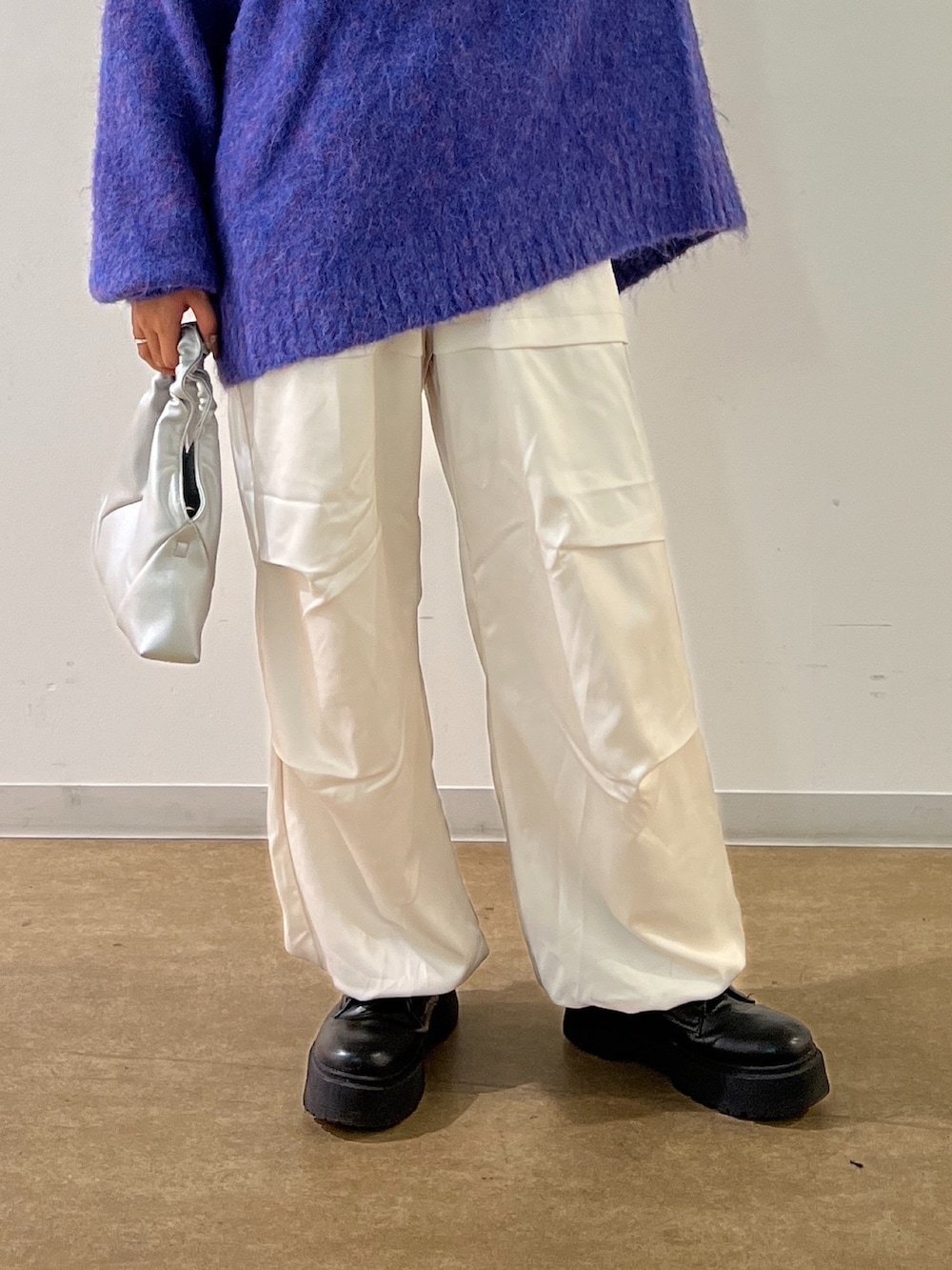ブルー系のニット/セーター、ホワイト系のカーゴパンツ、シルバー系のショルダーバッグを着用したレディースの秋コーディネートの3枚目の写真