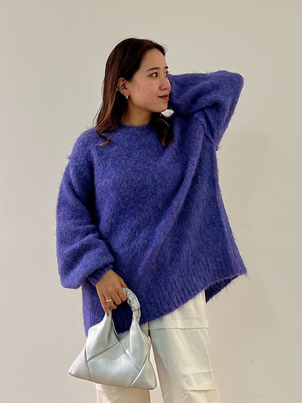 ブルー系のニット/セーター、ホワイト系のカーゴパンツ、シルバー系のショルダーバッグを着用したレディースの秋コーディネートの5枚目の写真