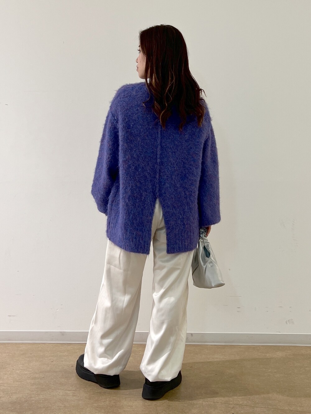 ブルー系のニット/セーター、ホワイト系のカーゴパンツ、シルバー系のショルダーバッグを着用したレディースの秋コーディネートの4枚目の写真