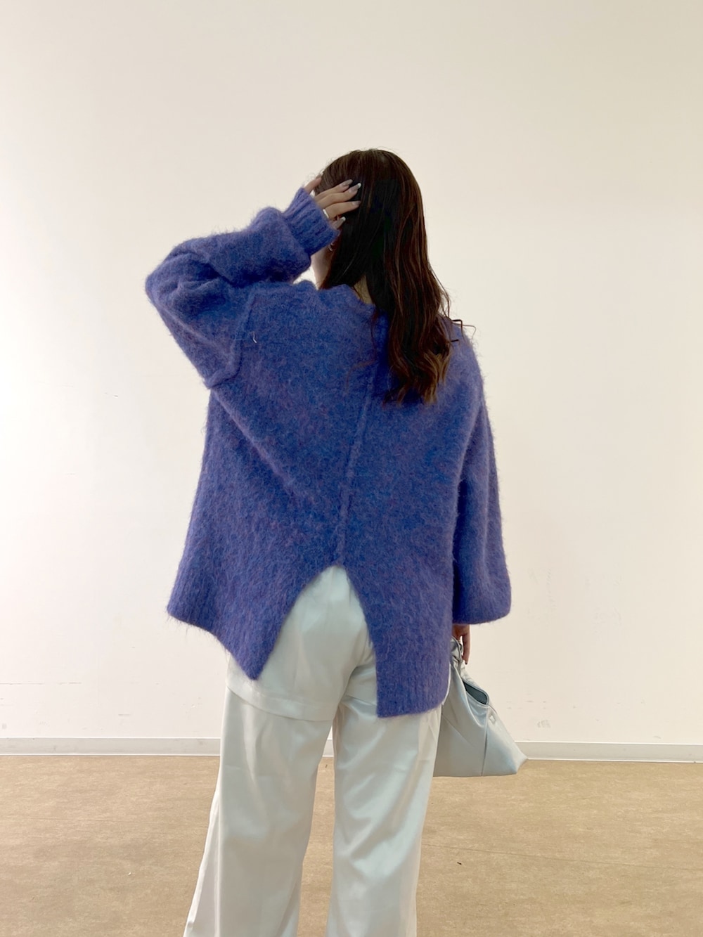 ブルー系のニット/セーター、ホワイト系のカーゴパンツ、シルバー系のショルダーバッグを着用したレディースの秋コーディネートの6枚目の写真