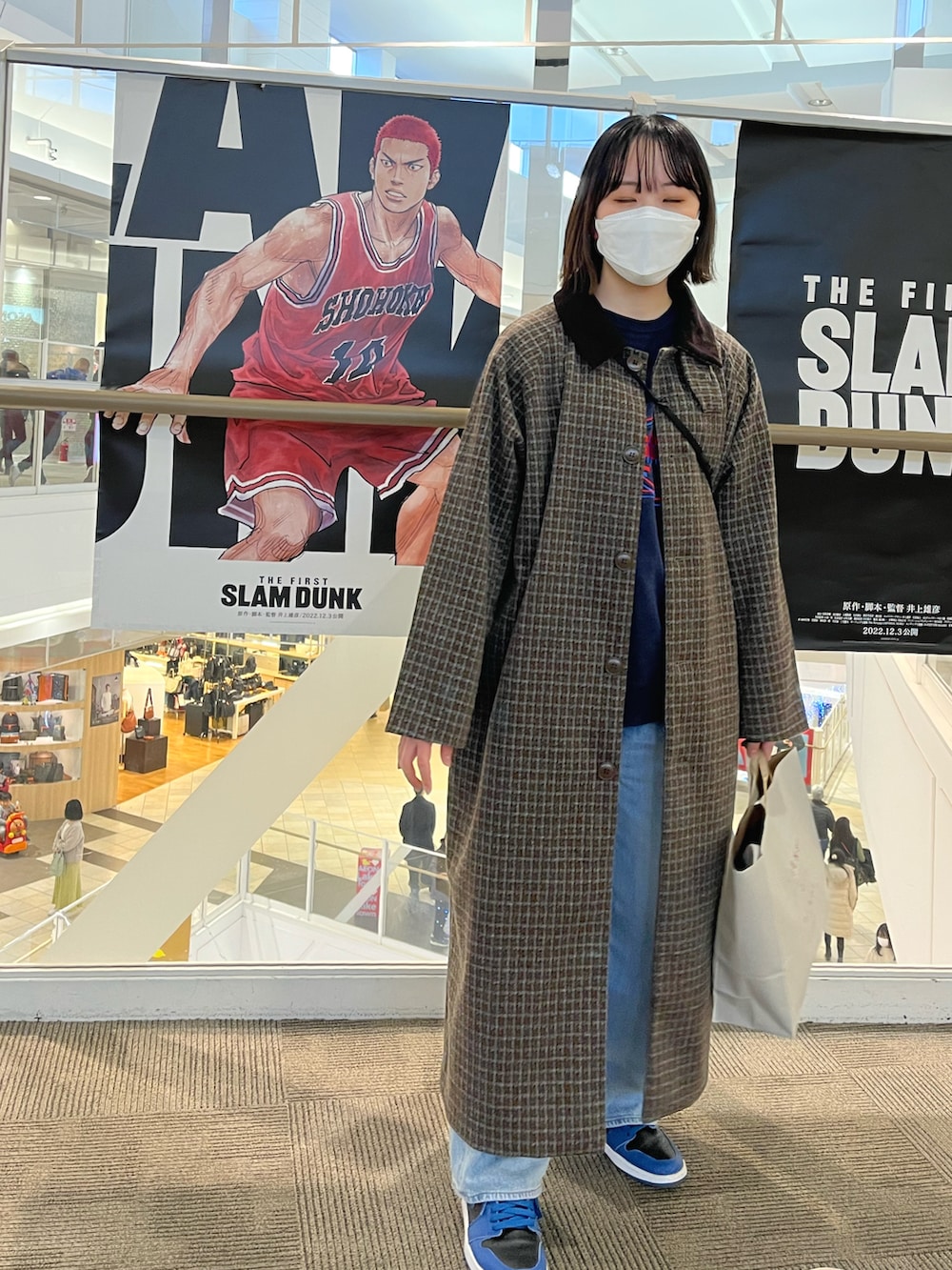 ブルー系のスウェット、ブラウン系のステンカラーコート、ブルー系のデニムパンツを着用したレディースの冬コーディネートの2枚目の写真