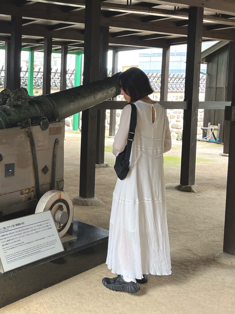 ホワイト系のワンピース、ブラック系のスニーカー、ブラック系のボディバッグ/ウエストポーチを着用したレディースの秋コーディネートの2枚目の写真