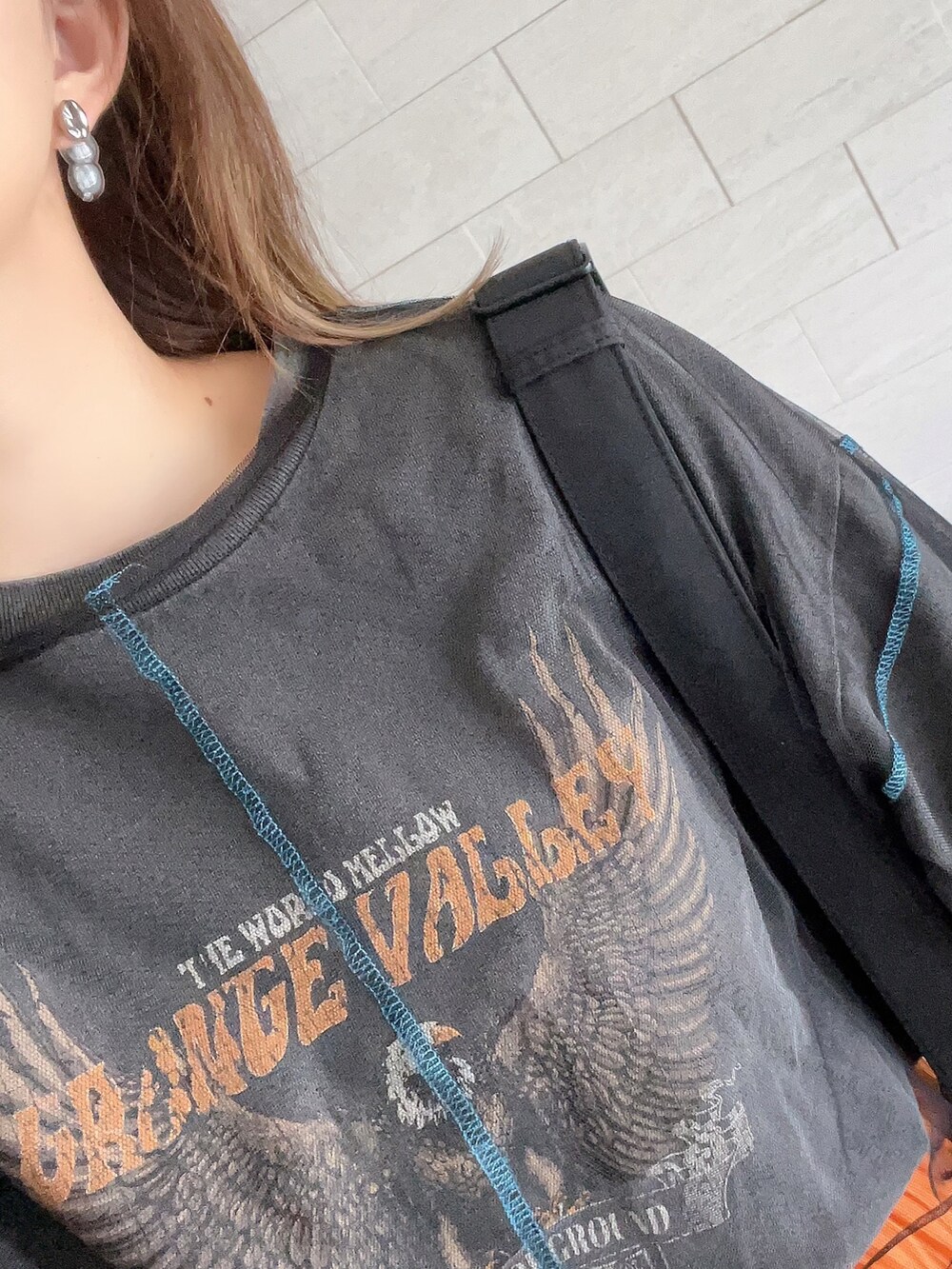 ホワイト系のスニーカー、オレンジ系のスカート、グレー系のTシャツ/カットソーを着用したレディースの夏コーディネートの3枚目の写真