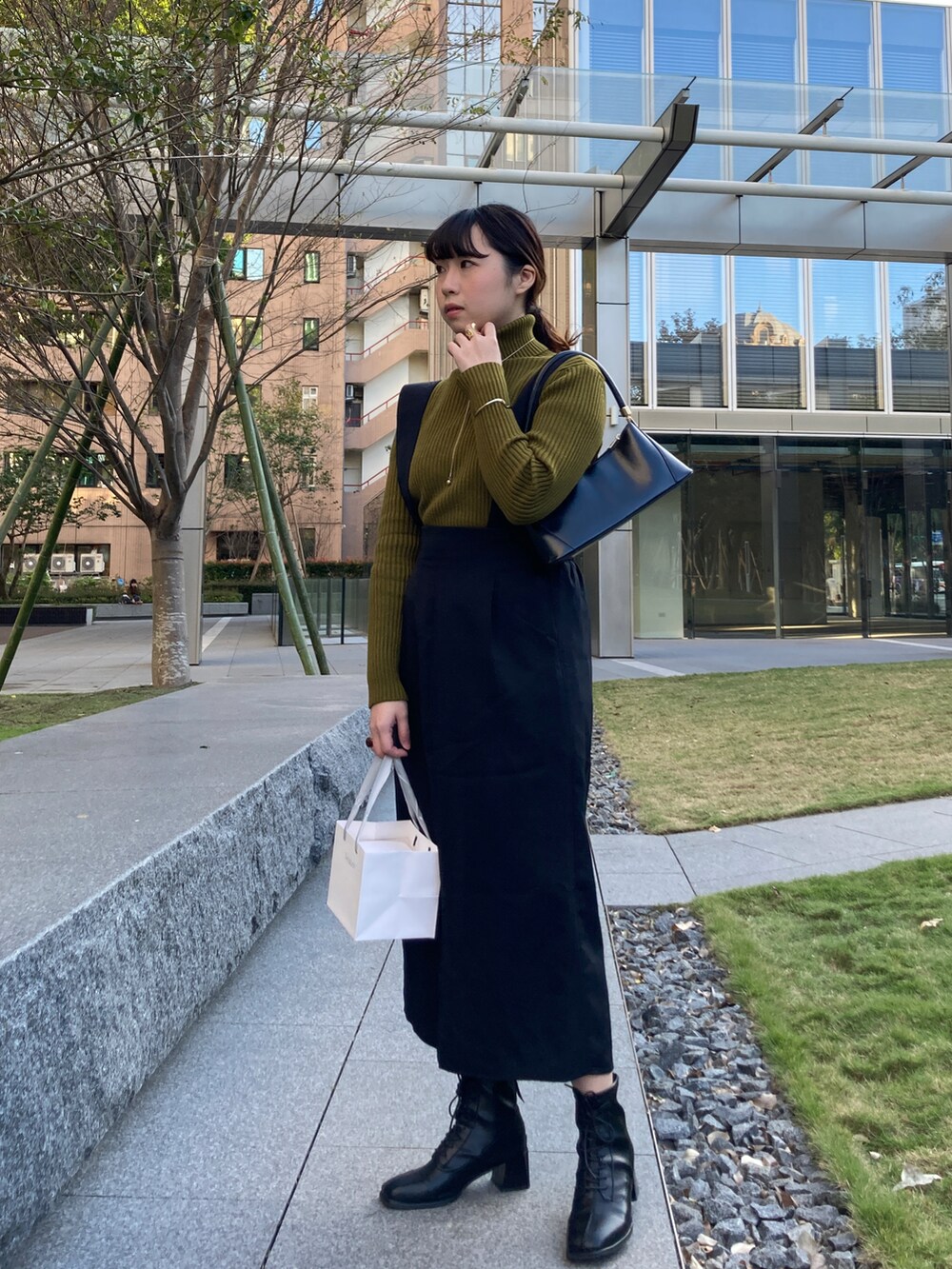 ブラック系のスカートを着用したレディースの春コーディネートの3枚目の写真
