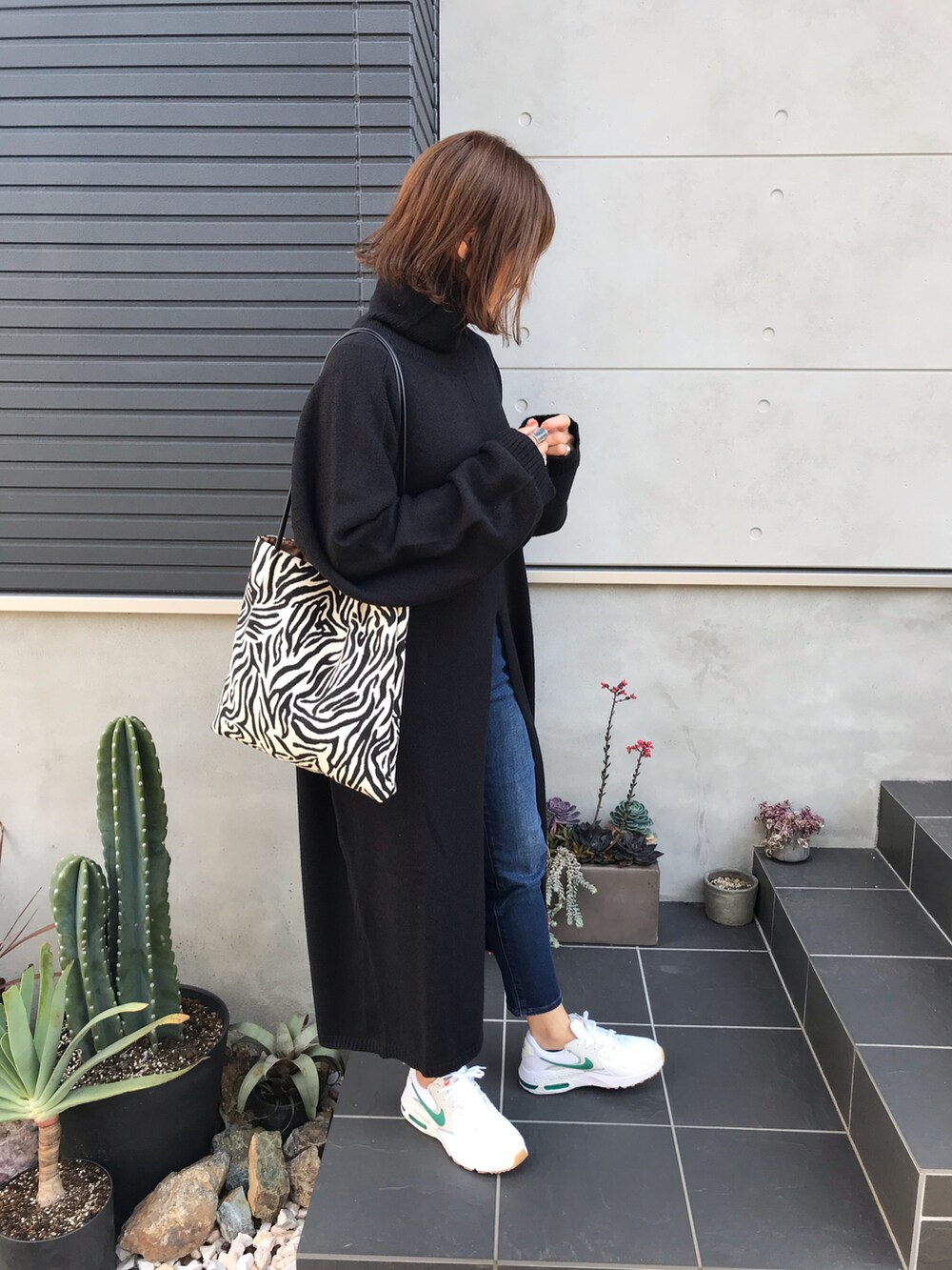 ブラック系のワンピース、ホワイト系のスニーカーを着用したレディースの秋コーディネートの3枚目の写真