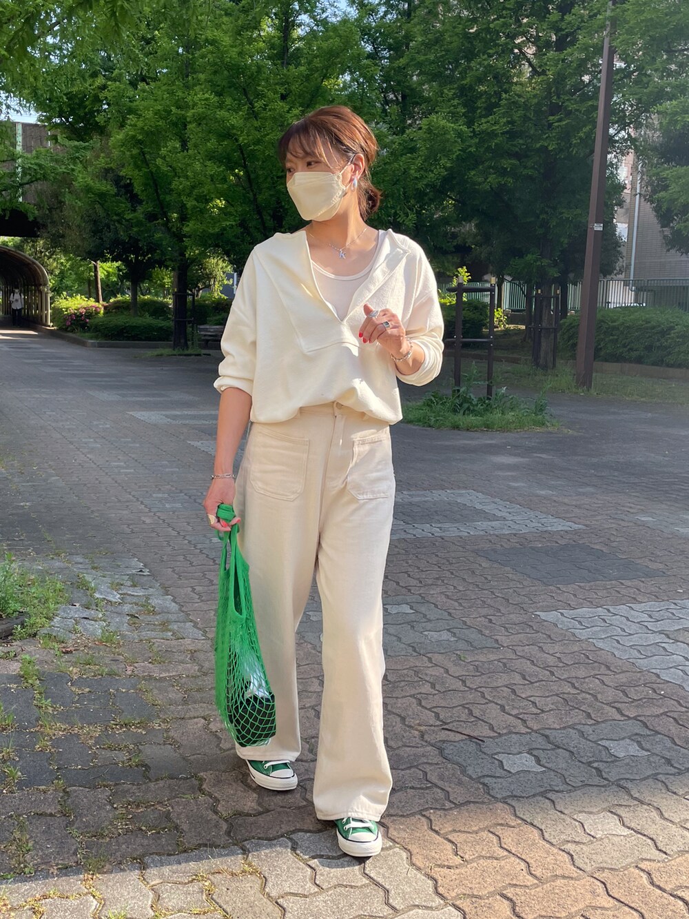 ホワイト系のTシャツ/カットソー、グリーン系のスニーカー、ホワイト系のチノパンツを着用したレディースの春コーディネートの2枚目の写真