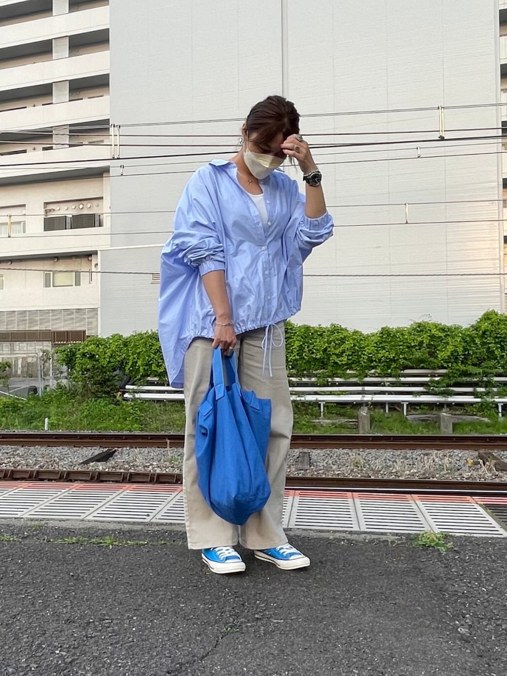 ブルー系のシャツ/ブラウス、ベージュ系のチノパンツ、ブルー系のスニーカーを着用したレディースの春コーディネートの2枚目の写真