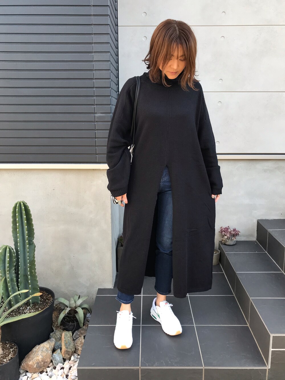 ブラック系のワンピース、ホワイト系のスニーカーを着用したレディースの秋コーディネートの2枚目の写真