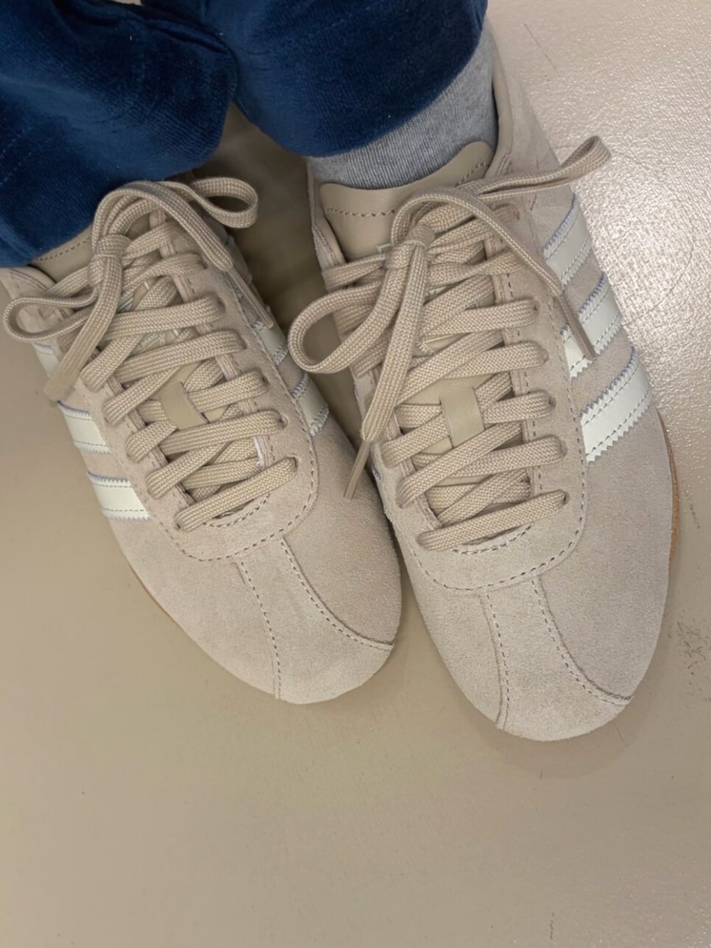 ホワイト系のTシャツ/カットソー、ベージュ系のスニーカー、ブラウン系のショルダーバッグを着用したレディースの冬コーディネートの4枚目の写真