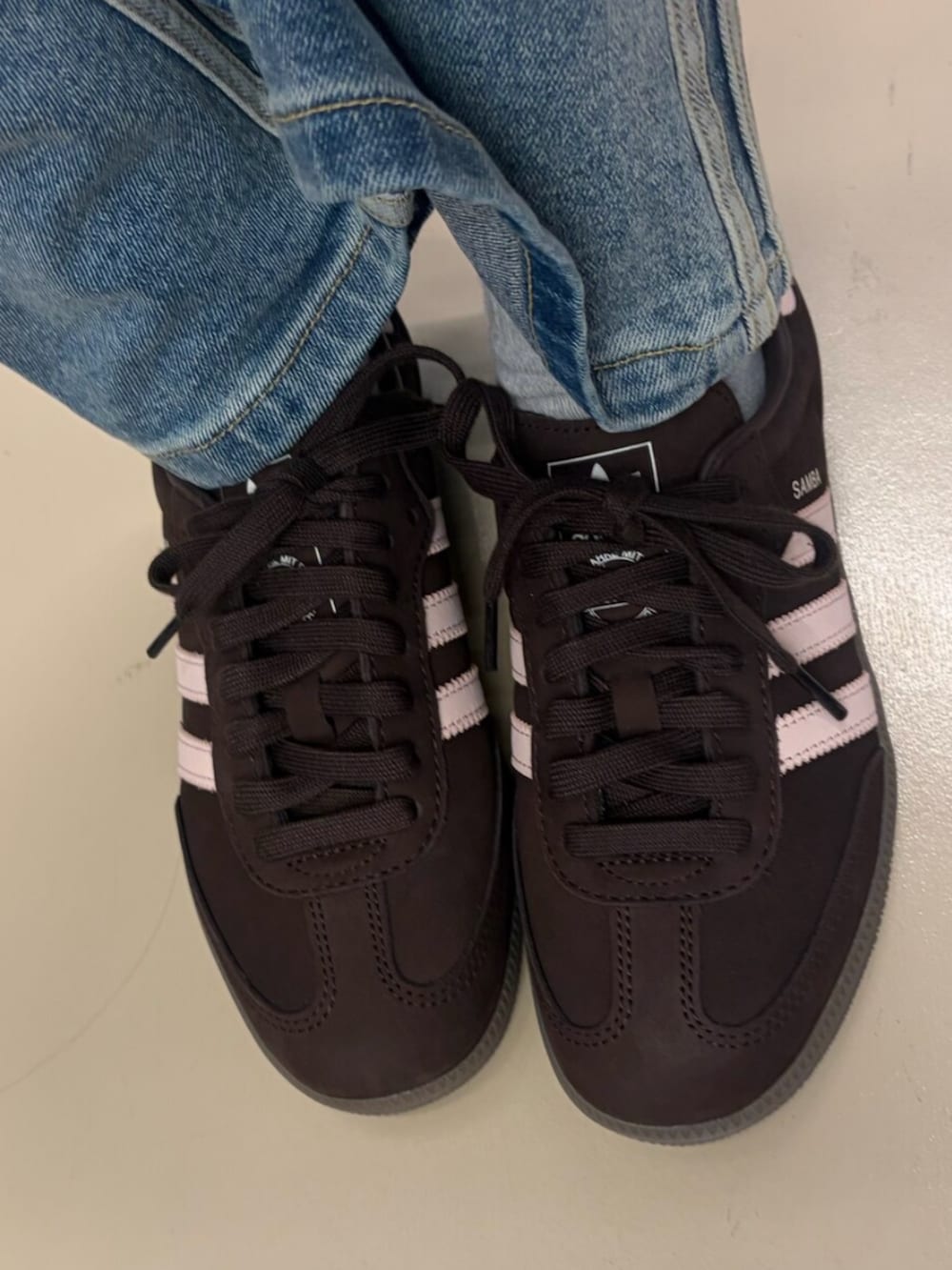 ブルー系のデニムパンツ、ブラウン系のスニーカー、ホワイト系のTシャツ/カットソーを着用したレディースの冬コーディネートの2枚目の写真