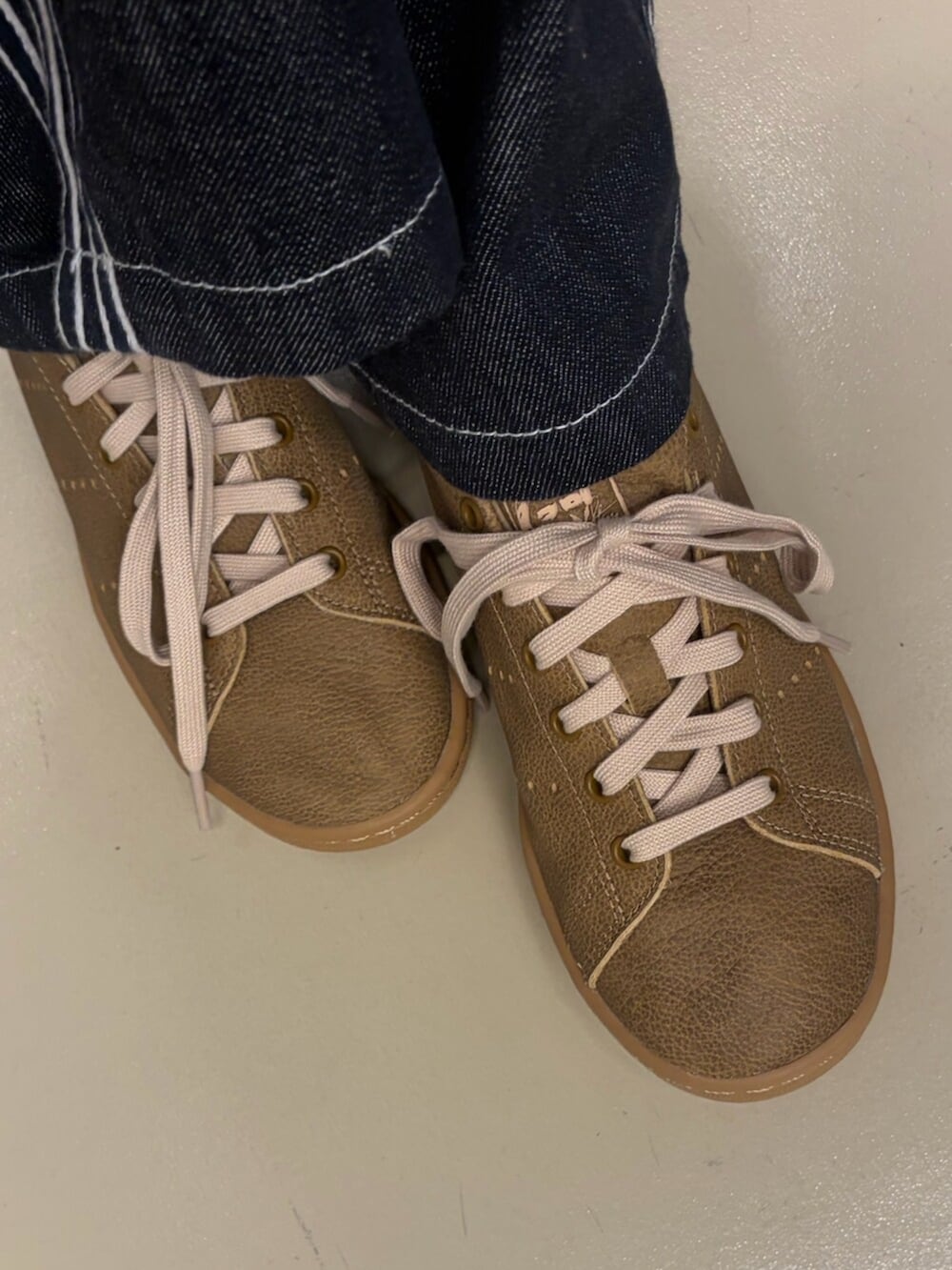 ブラック系のパーカー、ブルー系のデニムパンツ、ブラウン系のブルゾンを着用したレディースの冬コーディネートの2枚目の写真