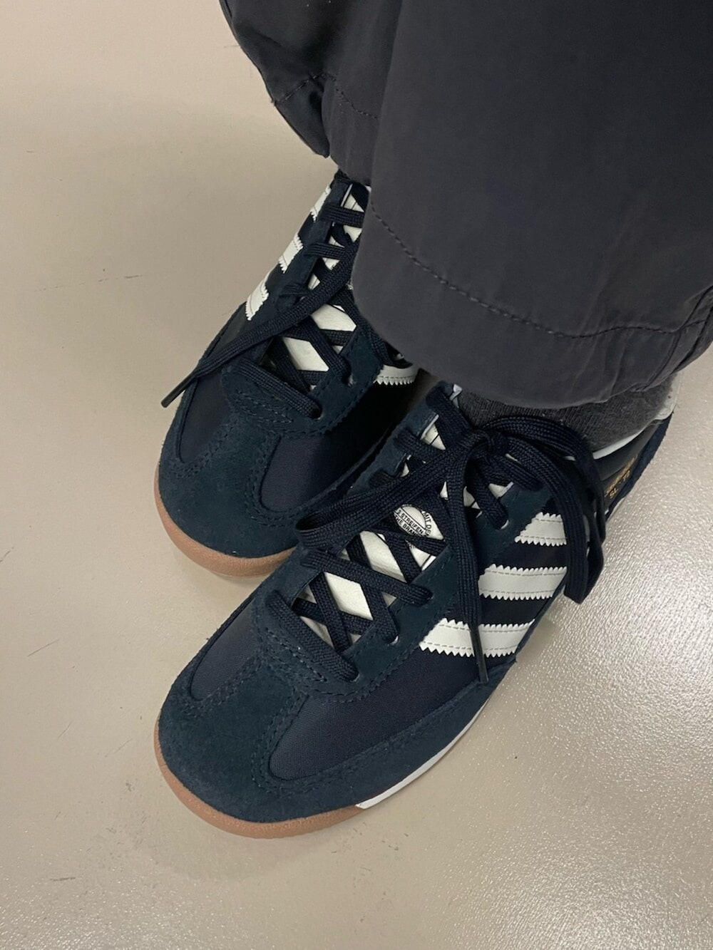 グレー系のスウェット、ブラック系のスニーカー、グレー系のカーゴパンツを着用したレディースの冬コーディネートの2枚目の写真