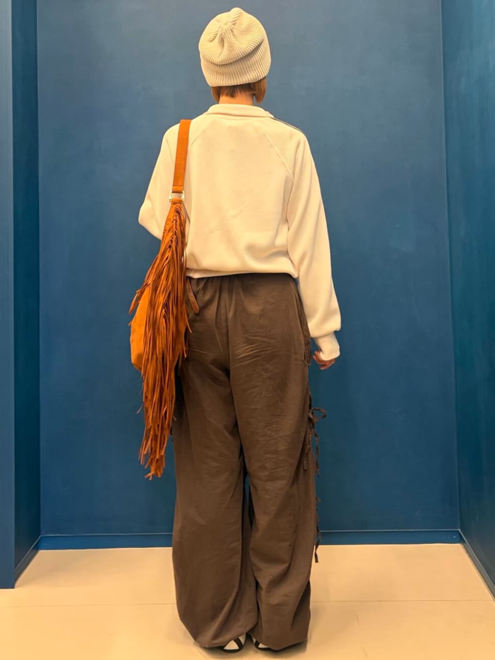 ホワイト系のスニーカー、ブラウン系のショルダーバッグ、ホワイト系のジャージを着用したレディースの冬コーディネートの2枚目の写真